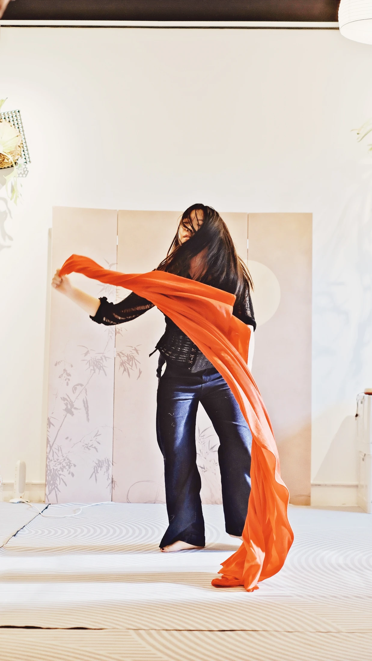 A participant developing an expressive movement study with flowing red fabric